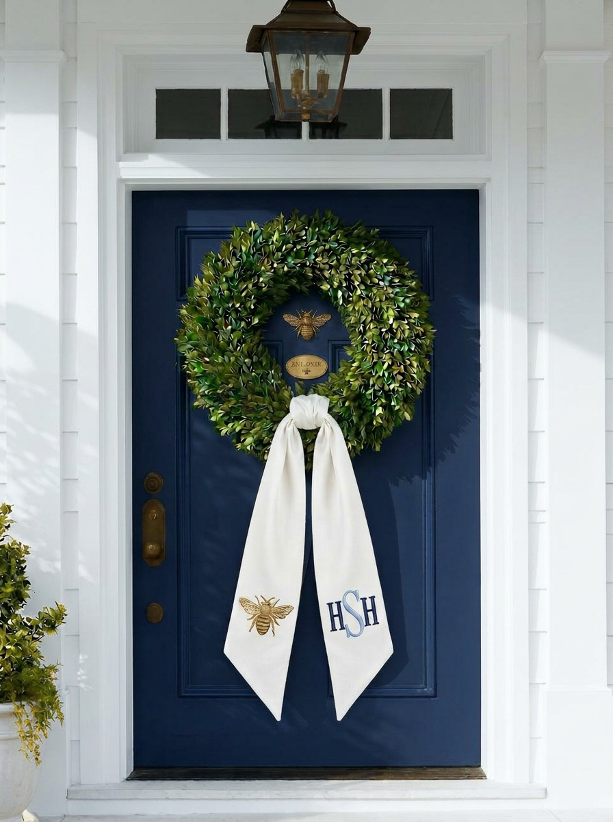 Navy front door styled with a lush boxwood wreath and a tailored blush and chinoiserie blue silk wreath sash